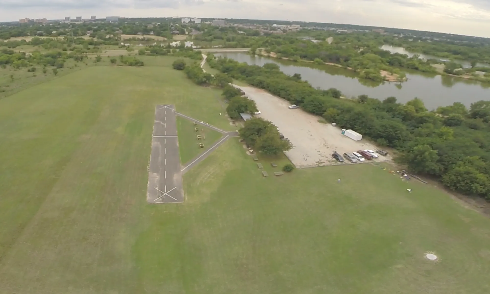 Aerial view of the Field: a paved runway and pilot stations in mowed grass beside Lake Hefner
